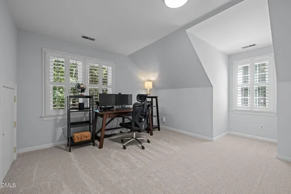 an empty room with windows and furniture