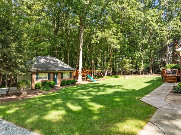 a view of an empty room with wooden floor and windows