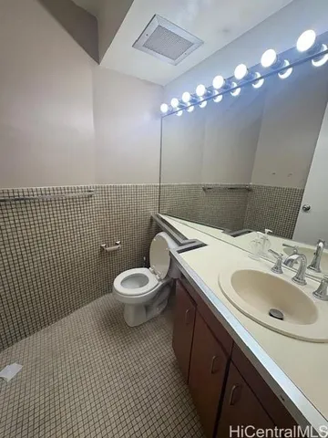 a bathroom with a sink a toilet a mirror and vanity