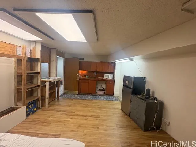 a view of a living room with kitchen furniture and a flat screen tv