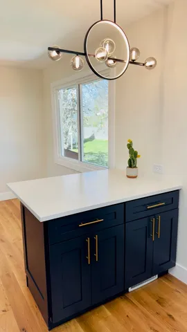 a kitchen with a wooden floor and a large window