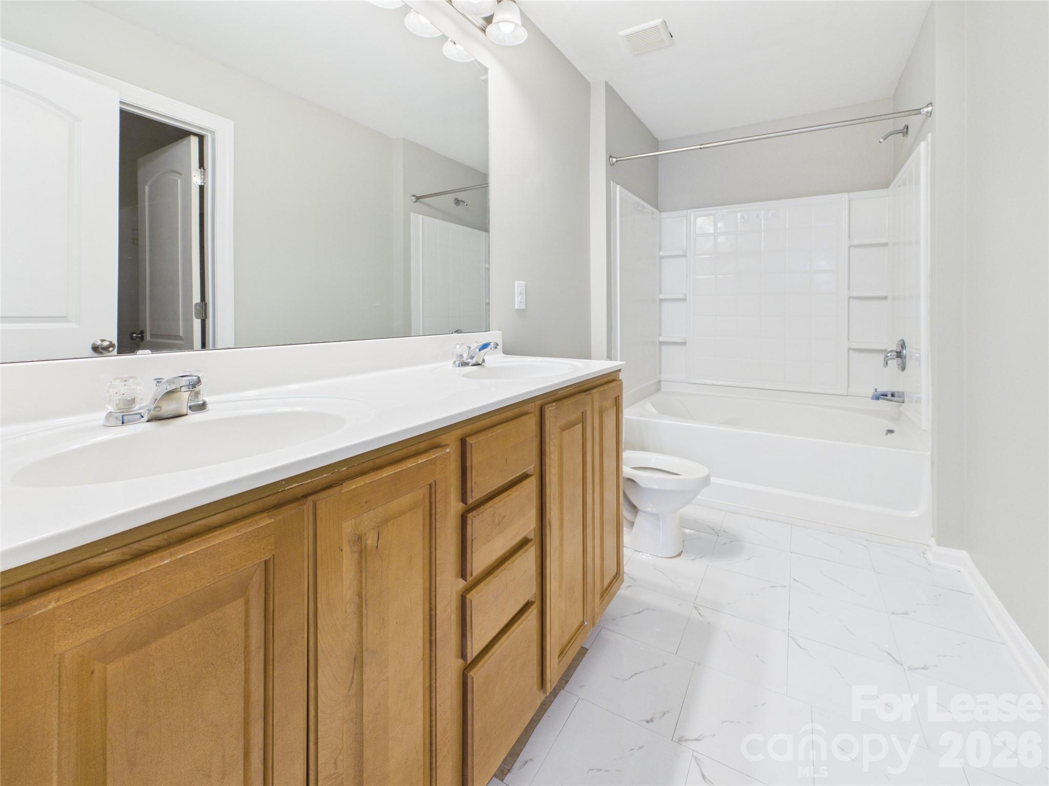 5690 Stafford Road Charlotte, NC 28215 - Photo 14 of 25 a bathroom with a granite countertop sink a toilet and shower