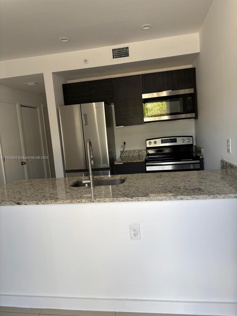 423 East 27th Street, Unit 101 Hialeah, FL 33013 - Photo 1 of 13 a kitchen with a sink and a mirror