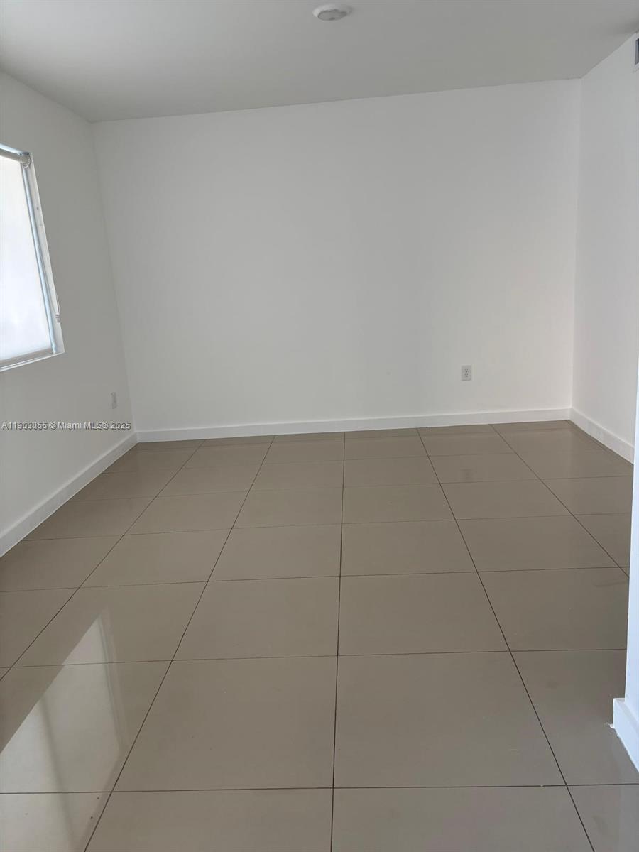 423 East 27th Street, Unit 101 Hialeah, FL 33013 - Photo 13 of 13 an empty room with a window
