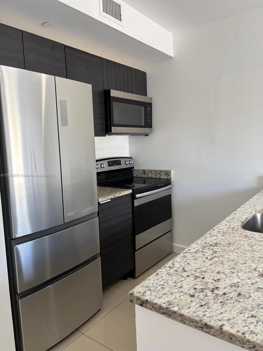 423 East 27th Street, Unit 101 Hialeah, FL 33013 - Photo 2 of 13 a kitchen with granite countertop stainless steel appliances and refrigerator