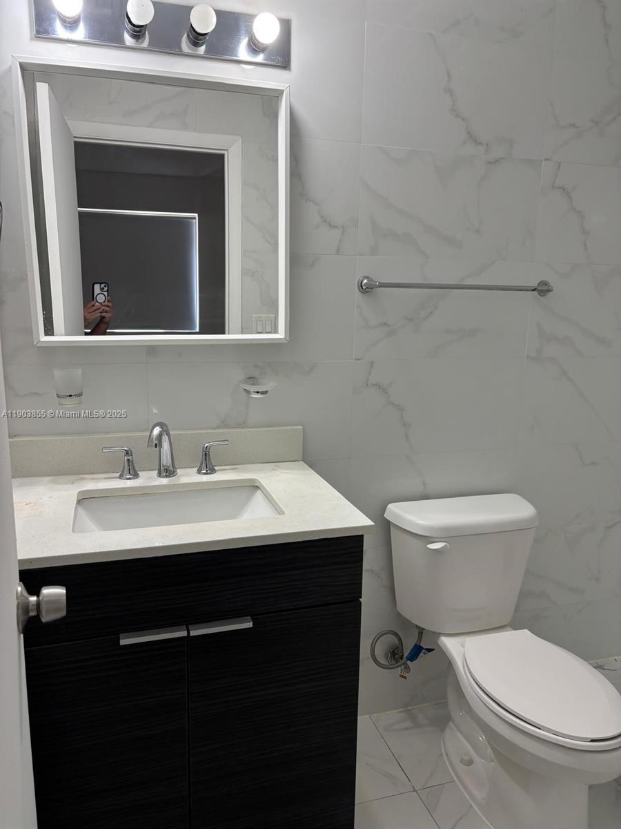 423 East 27th Street, Unit 101 Hialeah, FL 33013 - Photo 6 of 13 a bathroom with a toilet sink and mirror