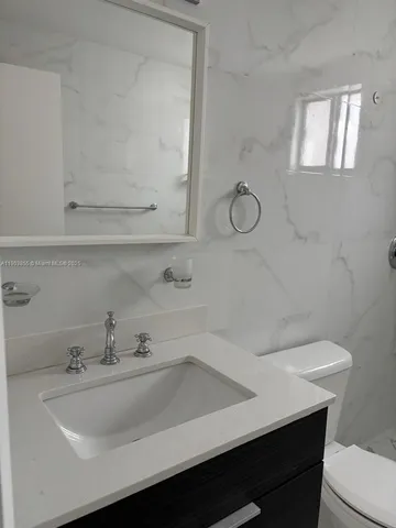 a bathroom with a sink a toilet and mirror