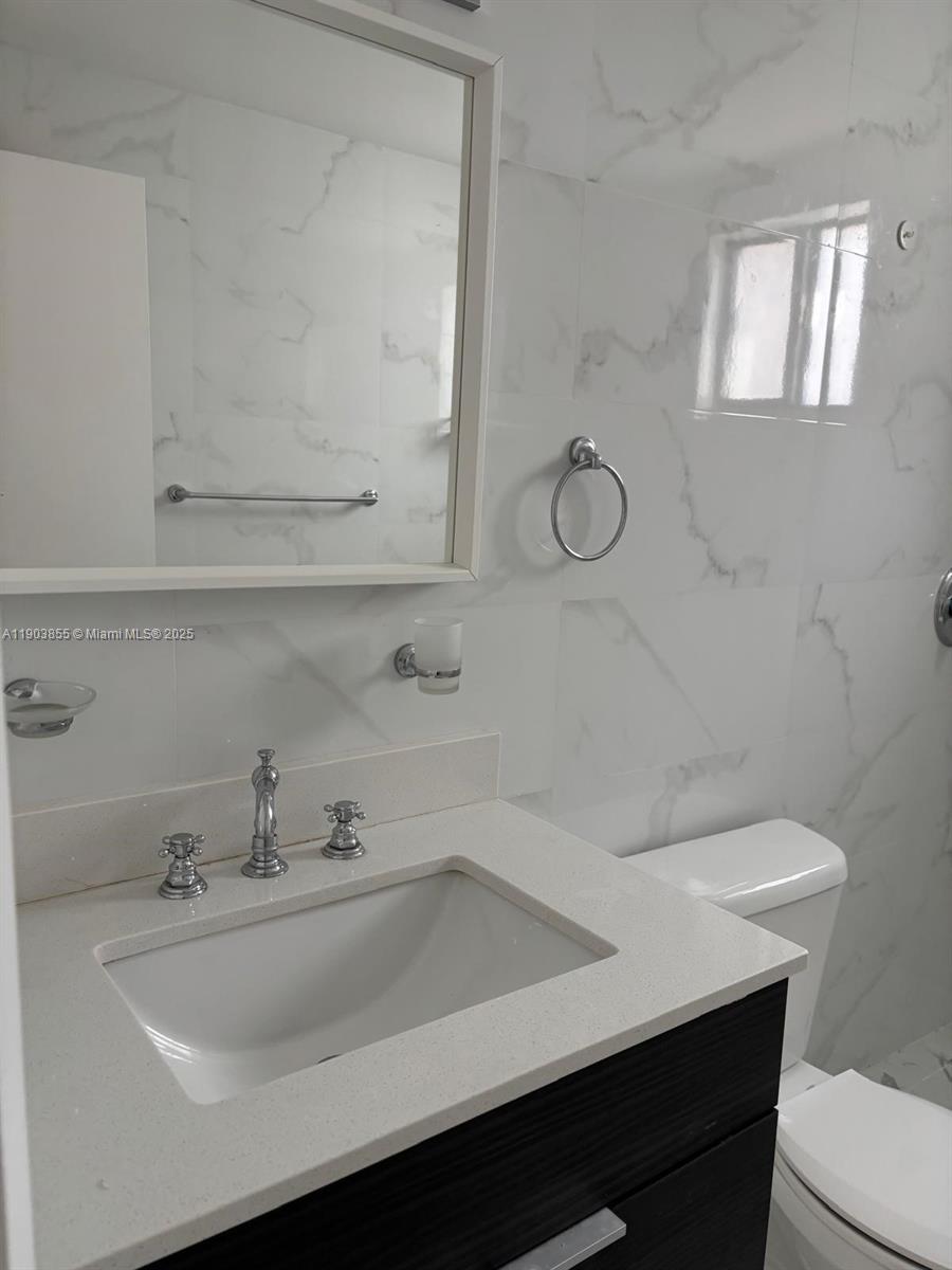 423 East 27th Street, Unit 101 Hialeah, FL 33013 - Photo 8 of 13 a bathroom with a sink and a toilet