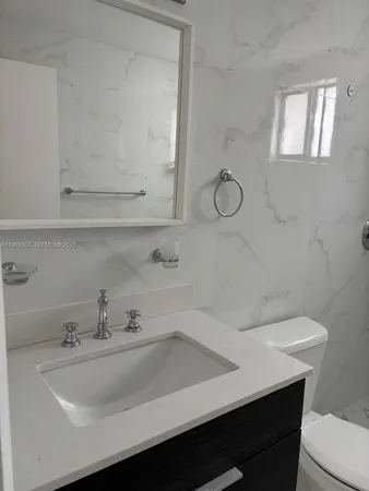 a bathroom with a sink a toilet and mirror