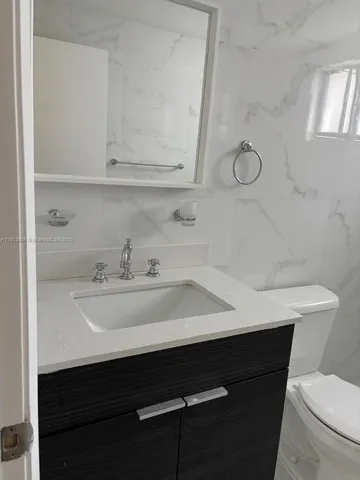 a view of bathroom with a sink and mirror