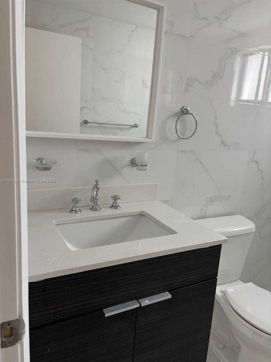 423 East 27th Street, Unit 101 Hialeah, FL 33013 - Photo 10 of 13 a bathroom with a sink a toilet and mirror
