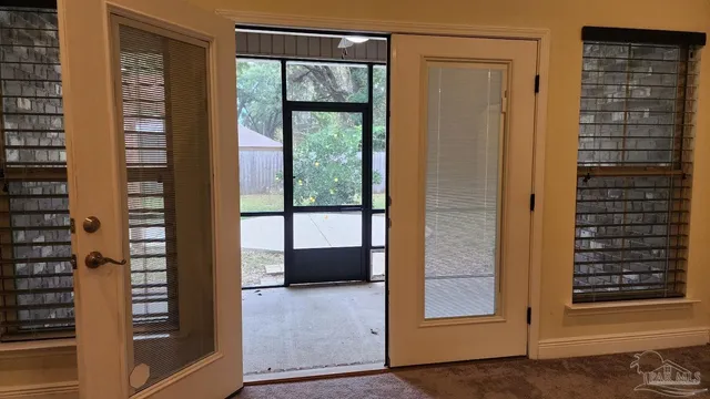a view of a backyard with floor to ceiling window and wooden fence