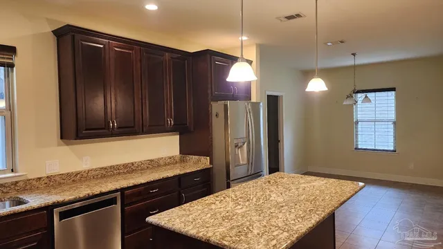 a kitchen with wooden cabinets and granite counter tops