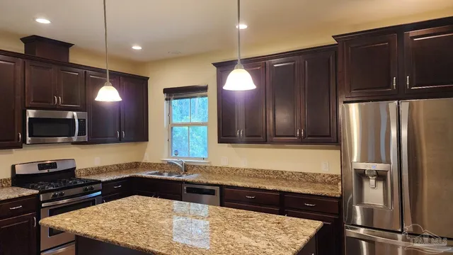 a kitchen with a refrigerator and a stove top oven