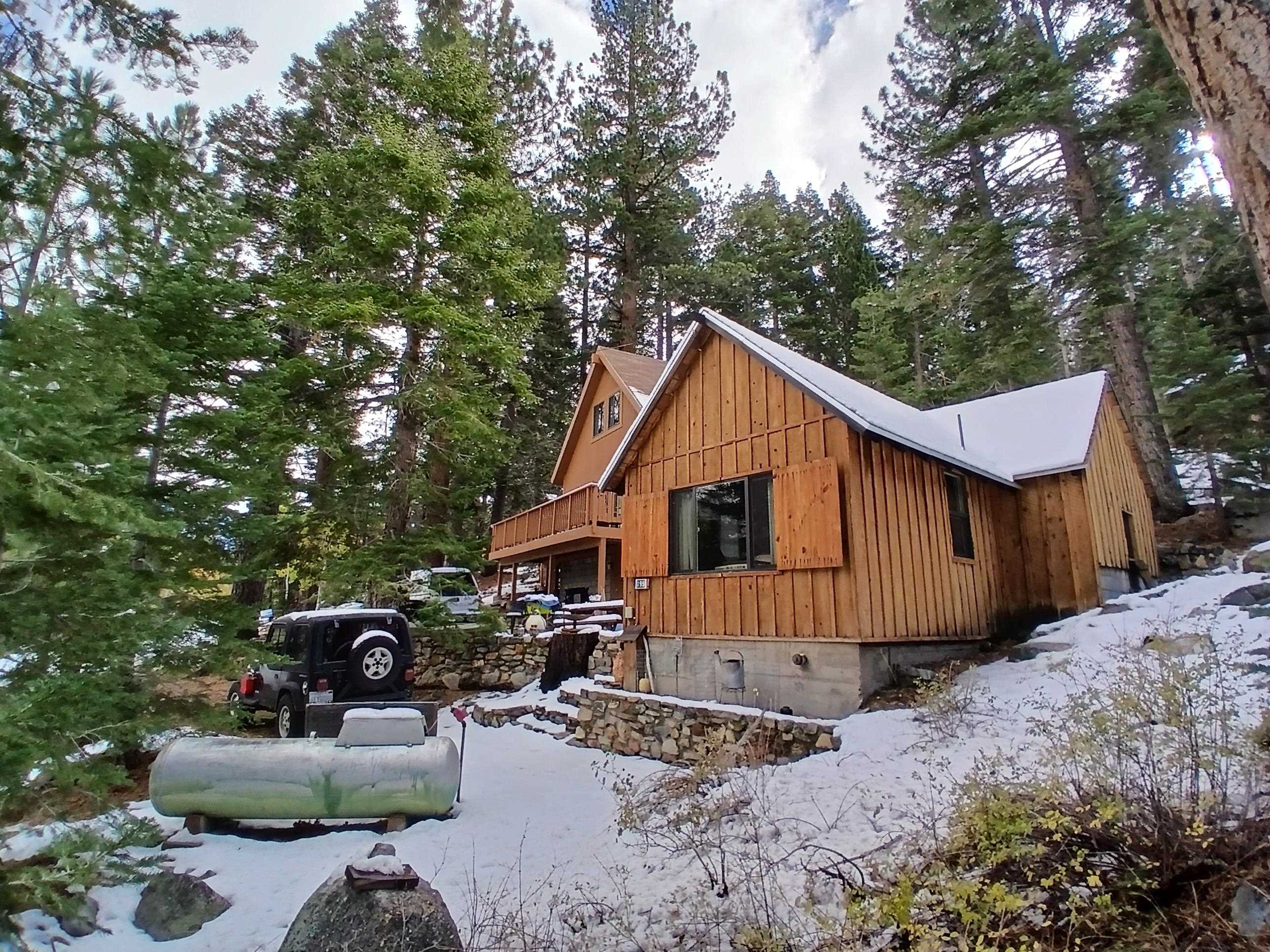 Wood-sided cabin exterior with a snow-dusted gabled roofline