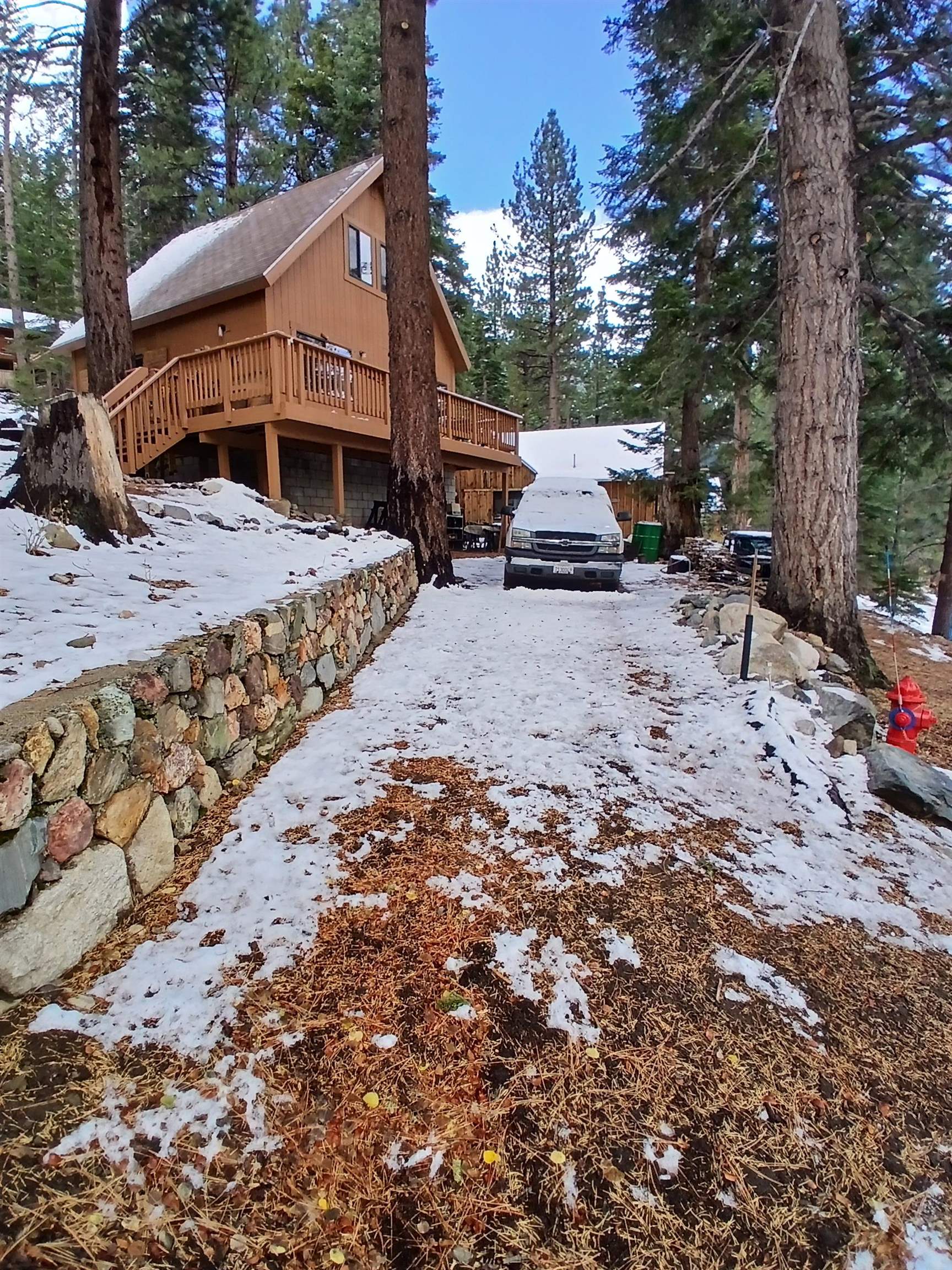 199 Hunewill Drive Bridgeport, CA 93517 - Photo 2 of 40 A-frame style exterior with wood siding, a multi-level wood deck, and a stone retaining wall