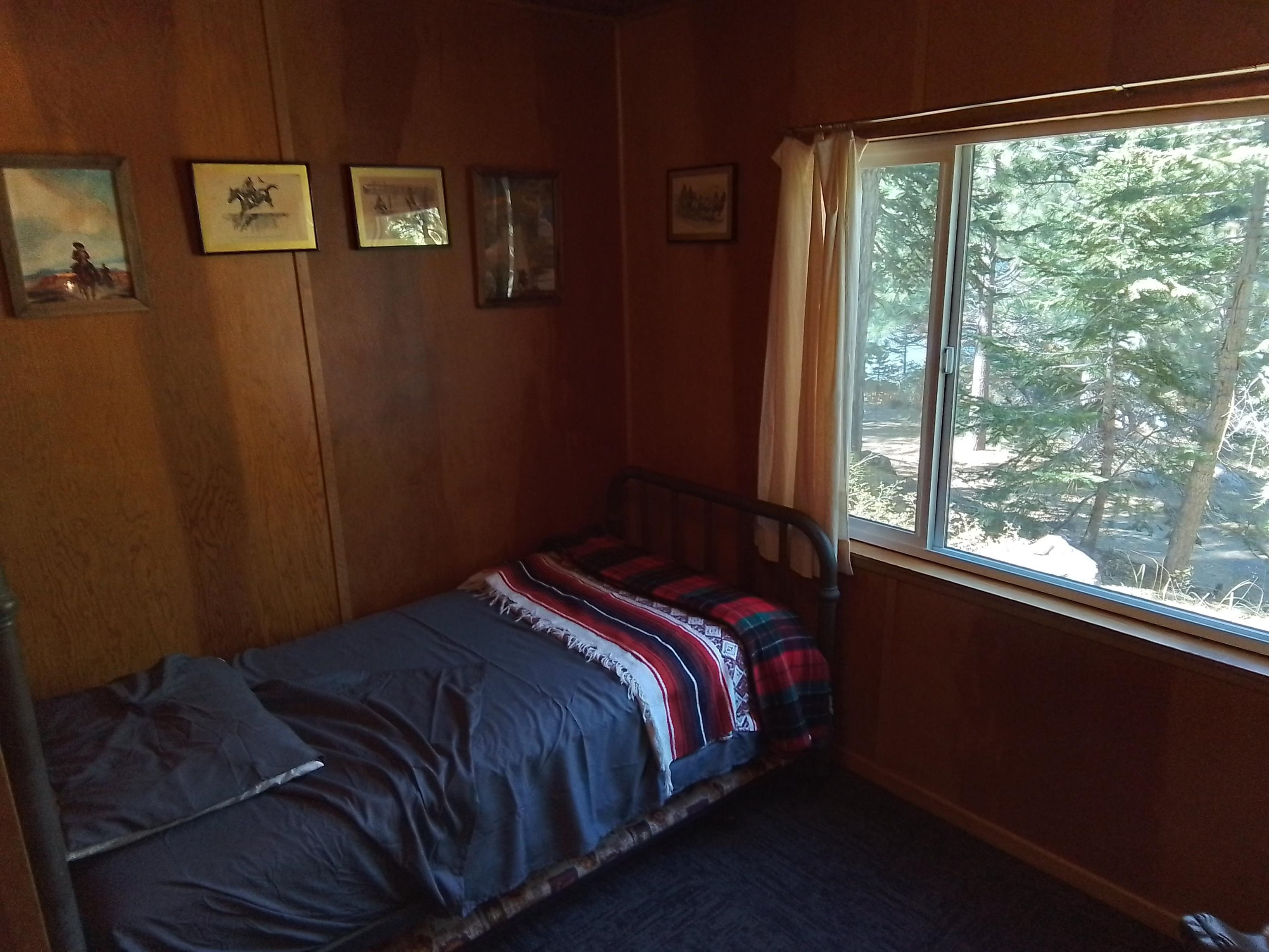 199 Hunewill Drive Bridgeport, CA 93517 - Photo 24 of 40 Wood paneling throughout this room, featuring a large window with white trim
