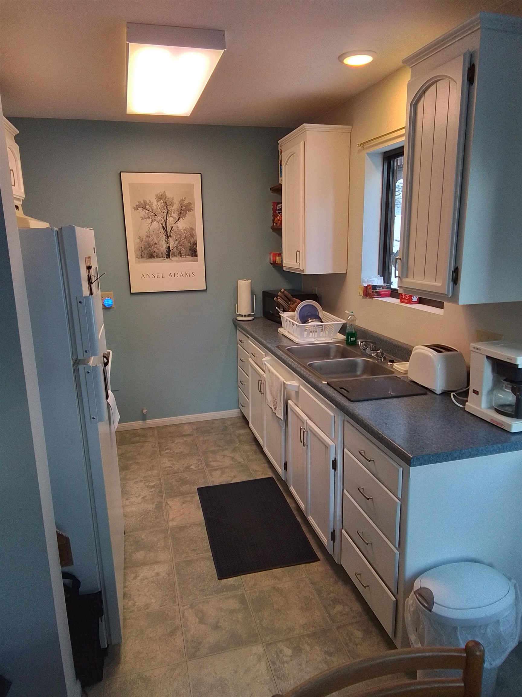 199 Hunewill Drive Bridgeport, CA 93517 - Photo 10 of 40 Kitchen featuring white cabinetry, a double basin sink, and a window above the counter