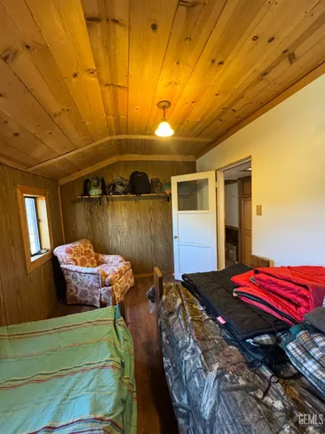 a spacious bedroom with a bed table and a chair
