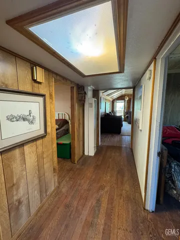 a view of a hallway with wooden floor and furniture