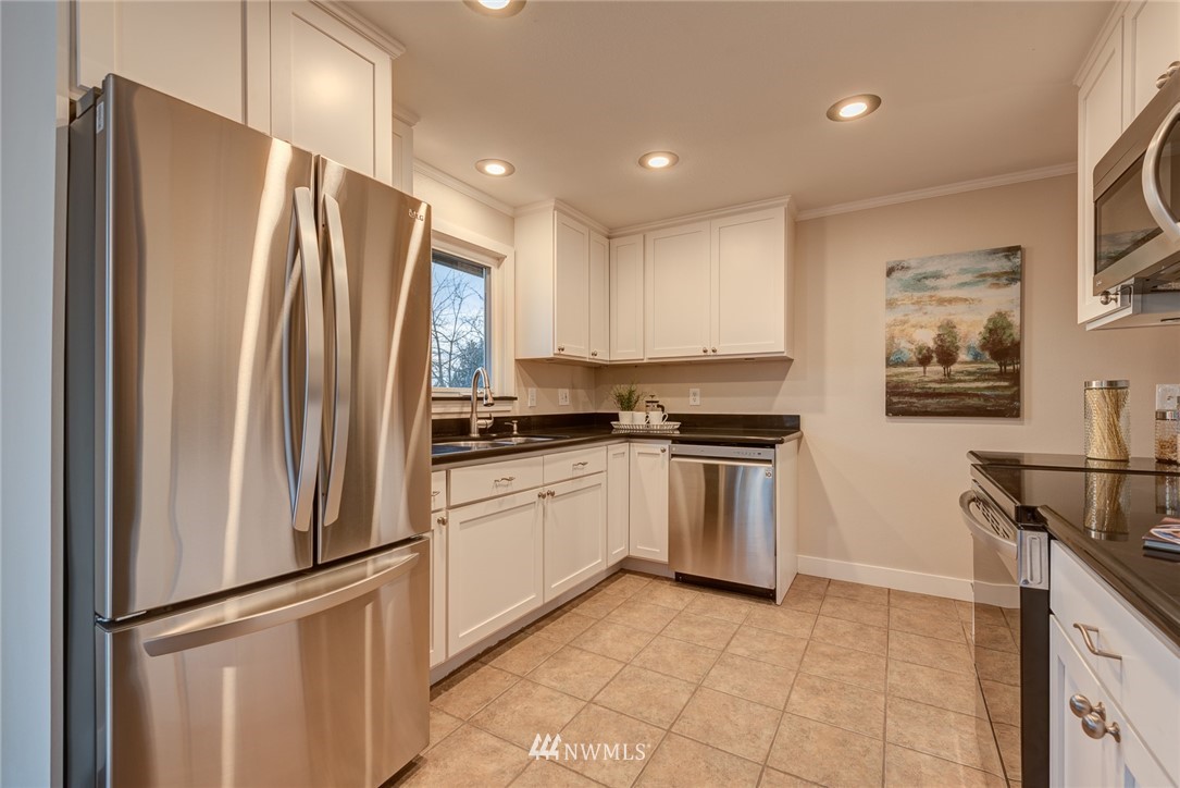 4314 Southwest Frontenac Street Seattle, WA 98136 - Photo 11 of 32 a kitchen with stainless steel appliances granite countertop a refrigerator and a stove top oven