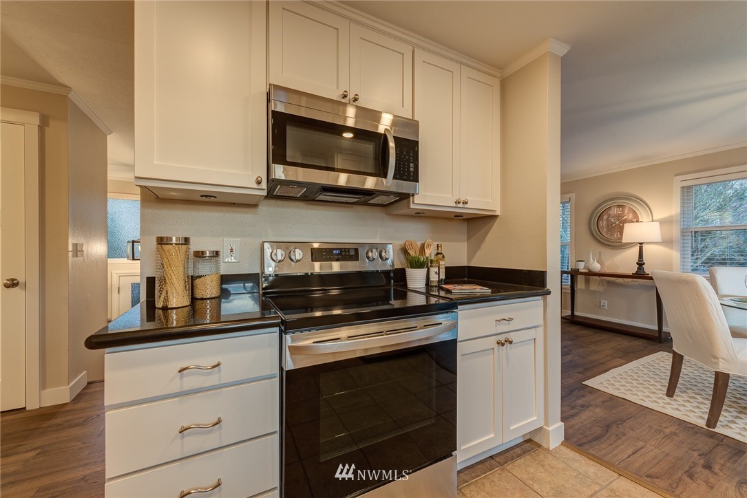 4314 Southwest Frontenac Street Seattle, WA 98136 - Photo 13 of 32 a kitchen with stainless steel appliances granite countertop a stove a sink and a microwave