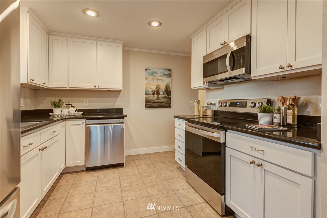 4314 Southwest Frontenac Street Seattle, WA 98136 - Photo 10 of 32 a kitchen with stainless steel appliances granite countertop a stove top oven a sink dishwasher and a refrigerator