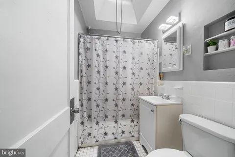 a bathroom with a toilet and a shower curtain