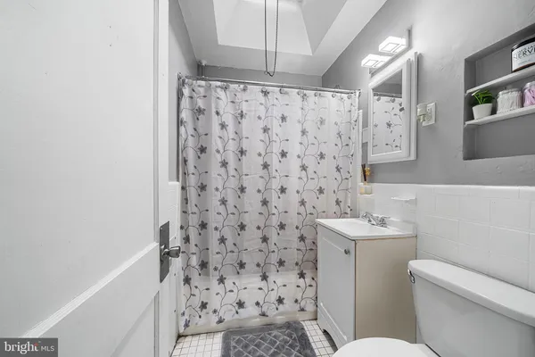 a bathroom with a toilet and a shower curtain