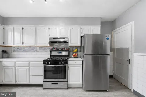 a kitchen with a refrigerator stove and white cabinets