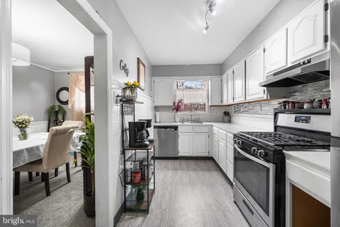 a kitchen with granite countertop a stove a sink dishwasher and a refrigerator