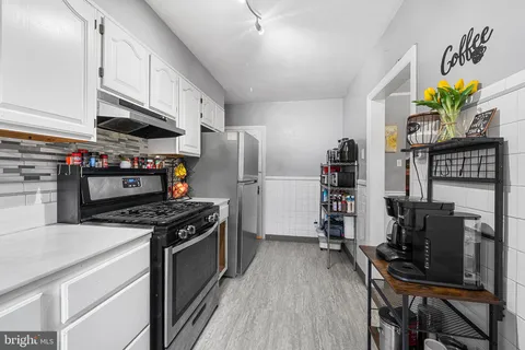 a kitchen with stainless steel appliances a stove a refrigerator a sink a stove and a refrigerator