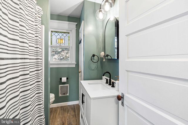 a bathroom with a sink and mirror with toilet