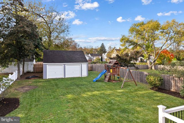 a view of a house with a backyard and a tree