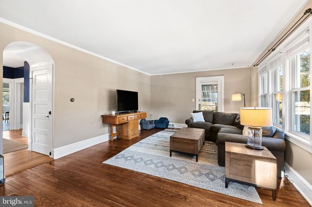 a living room with furniture a flat screen tv and a large window