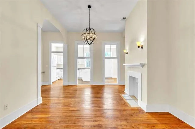 a view of empty room with wooden floor and window