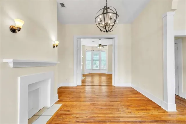 a view of hallway with wooden floor and chandelier