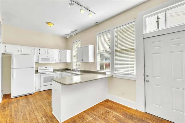 a kitchen with a sink cabinets and wooden floor