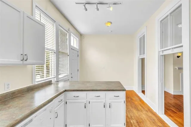 a kitchen with granite countertop white cabinets and white appliances