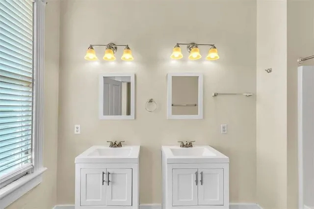 a bathroom with double sink and a mirror
