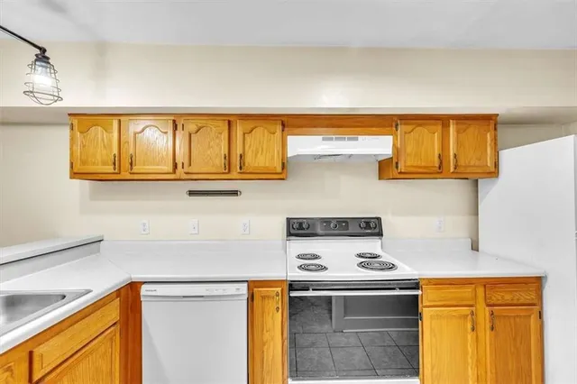 a kitchen with stainless steel appliances granite countertop a stove a sink and dishwasher