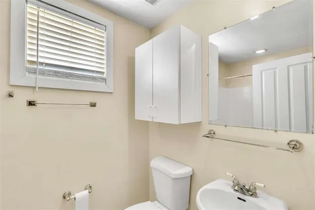 a bathroom with a sink a toilet and a mirror