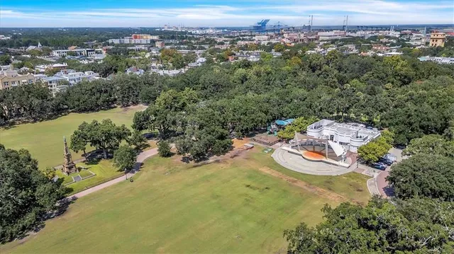 an aerial view of a residential houses with outdoor space and trees
