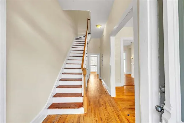 a view of a hallway with wooden floor and entryway