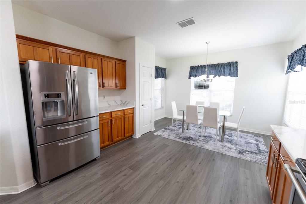 12855 Southeast 92nd Court Road Summerfield, FL 34491 - Photo 17 of 61 a kitchen with stainless steel appliances granite countertop a refrigerator microwave and wooden floor