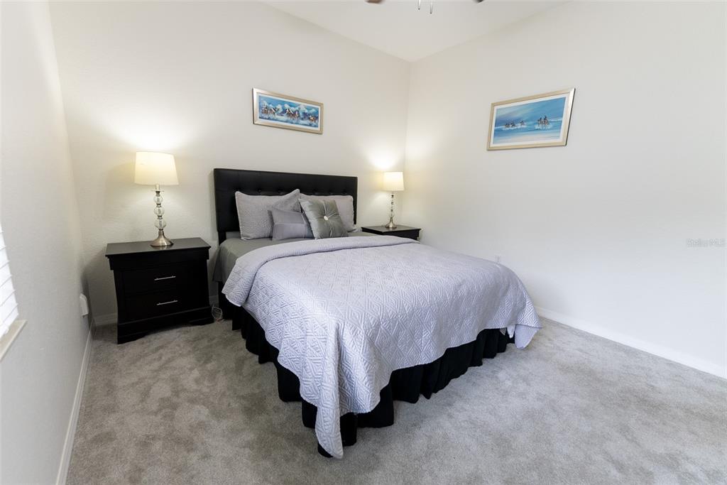 12855 Southeast 92nd Court Road Summerfield, FL 34491 - Photo 28 of 61 a bedroom with a bed and a lamp