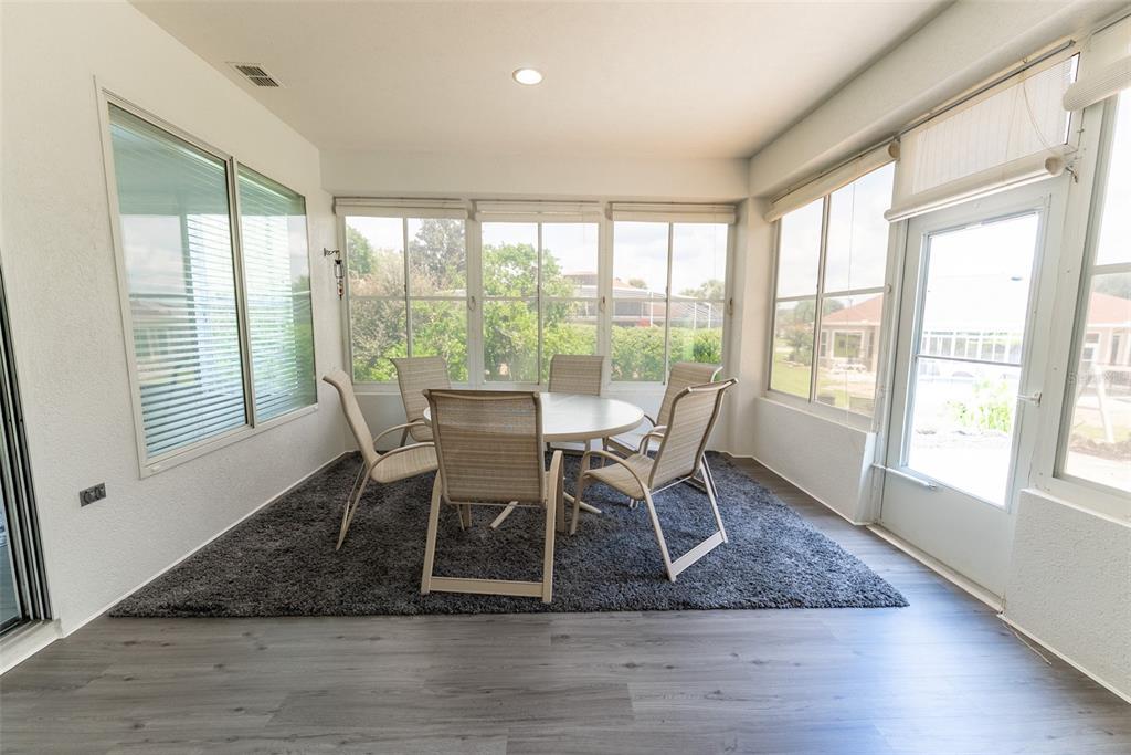 12855 Southeast 92nd Court Road Summerfield, FL 34491 - Photo 52 of 61 a dining room with wooden floor and a floor to ceiling window