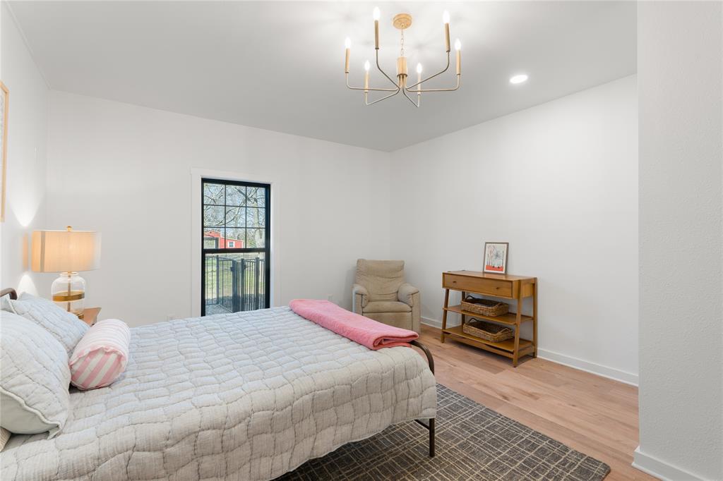 990 Cornelius Road Rockwall, TX 75087 - Photo 26 of 37 a bedroom with a bed and a chandelier