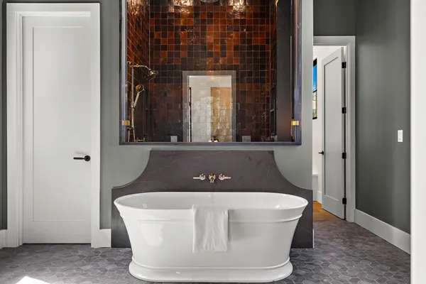 a spacious bathroom with a tub sink and mirror