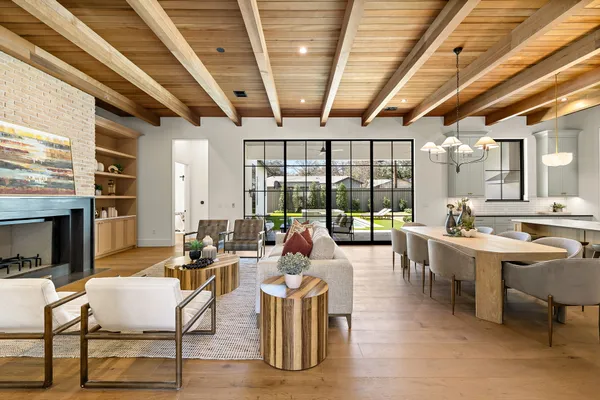 a living room with fireplace furniture and a large window